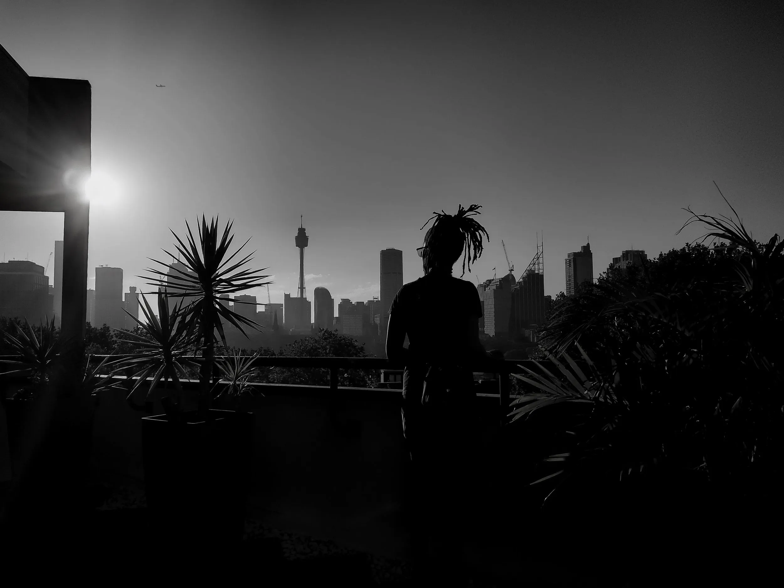 Cheryl Benson silhouetted against a city skyline at sunset